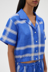 Profile view of model wearing the Oroton Vintage Check Short Sleeve Shirt in Swedish Blue and 100% midweight linen fabric for Women .