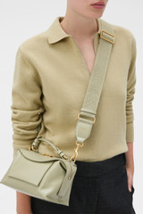Profile view of model wearing the Oroton Logo Crackle Bag Strap in Pistachio and Jacquard webbing material for Women .