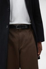 Profile view of model wearing the Oroton Axel 30MM Belt in Black and Premium box leather for Men .