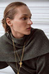 Profile view of model wearing the Oroton Billie Key Pendant in Worn Gold and Brass material for Women .