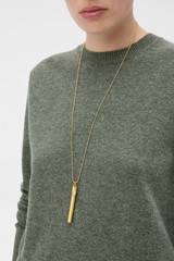 Profile view of model wearing the Oroton Billie Pendant in Worn Gold and Brass material for Women .