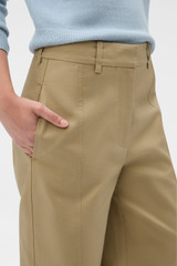 Profile view of model wearing the Oroton Tailored Curved Leg Pant in Haystack and 100% cotton fabric for Women .