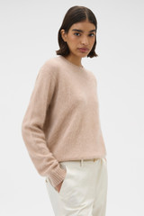 Profile view of model wearing the Oroton Cashmere Blend Knit in Biscotti and 	
70% ultra-fine merino wool and 30% cashmere blend fabric for Women .