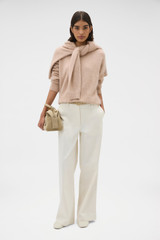 Profile view of model wearing the Oroton Cashmere Blend Knit in Biscotti and 	
70% ultra-fine merino wool and 30% cashmere blend fabric for Women .