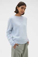 Profile view of model wearing the Oroton Cashmere Blend Knit in Soft Blue and 	
70% ultra-fine merino wool and 30% cashmere blend fabric for Women .
