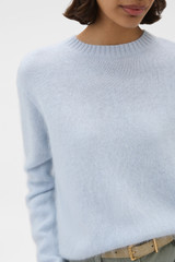 Profile view of model wearing the Oroton Cashmere Blend Knit in Soft Blue and 	
70% ultra-fine merino wool and 30% cashmere blend fabric for Women .