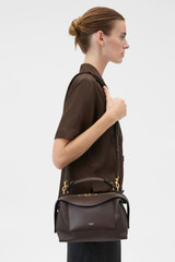 Profile view of model wearing the Oroton Mica Bowler in Dark Chocolate and Premium pebble grain leather for Women .