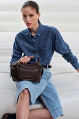 Profile view of model wearing the Oroton Mica Bowler in Dark Chocolate and Premium pebble grain leather for Women .