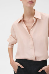 Profile view of model wearing the Oroton Long Sleeve Shirt in Rose Tint and 100% silk habotai fabric for Women .