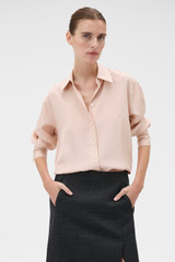 Profile view of model wearing the Oroton Long Sleeve Shirt in Rose Tint and 100% silk habotai fabric for Women .