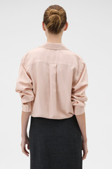 Profile view of model wearing the Oroton Long Sleeve Shirt in Rose Tint and 100% silk habotai fabric for Women .