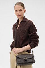 Profile view of model wearing the Oroton Dylan Signature Buckle Day Bag in Burnt Umber and Printed PVC-coated nylon canvas material for Women .