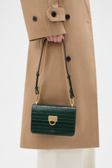Profile view of model wearing the Oroton Yvette Texture Small Clutch Day Bag in Evergreen and Premium embossed crocodile leather for Women .