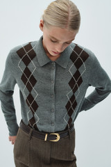 Profile view of model wearing the Oroton Argyle Cardigan in Grey Marle and 55% extra fine merino wool and 45% cotton blend fabric for Women .