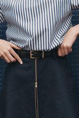 Profile view of model wearing the Oroton Remi 25MM Belt in Black and Premium textured leather material for Women .