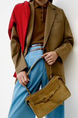 Profile view of model wearing the Oroton Cleo Suede Shoulder Bag in Tobacco and Premium suede leather for Women .