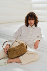 Profile view of model wearing the Oroton Cleo Suede Shoulder Bag in Tobacco and Premium suede leather for Women .