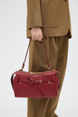 Profile view of model wearing the Oroton Cleo Smooth Shoulder Bag in Garnet and Premium smooth leather for Women .