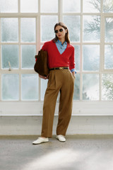 Profile view of model wearing the Oroton Tapered Pleat Pant in Dark Rye and 97% wool and 3% spandex blend fabric for Women .