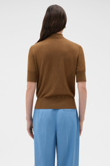 Profile view of model wearing the Oroton Knit Polo Top in Dark Rye and 90% merino wool and 10% silk blend fabric for Women .