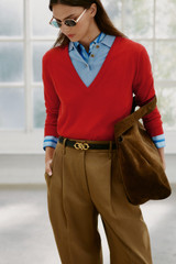 Profile view of model wearing the Oroton Deep V Knit in Poppy and 90% merino wool and 10% silk blend fabric for Women .
