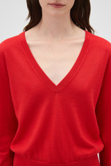 Profile view of model wearing the Oroton Deep V Knit in Poppy and 90% merino wool and 10% silk blend fabric for Women .