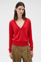 Profile view of model wearing the Oroton Deep V Knit in Poppy and 90% merino wool and 10% silk blend fabric for Women .