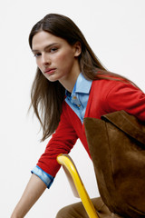 Profile view of model wearing the Oroton Deep V Knit in Poppy and 90% merino wool and 10% silk blend fabric for Women .