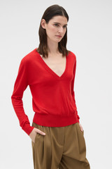 Profile view of model wearing the Oroton Deep V Knit in Poppy and 90% merino wool and 10% silk blend fabric for Women .