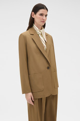 Profile view of model wearing the Oroton Single Breasted Blazer in Dark Rye and 100% wool fabric for Women .