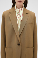 Profile view of model wearing the Oroton Single Breasted Blazer in Dark Rye and 100% wool fabric for Women .