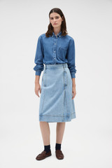 Profile view of model wearing the Oroton Button Detail Denim Skirt in Light Vintage Wash and 100% cotton fabric for Women .
