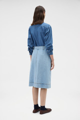 Profile view of model wearing the Oroton Button Detail Denim Skirt in Light Vintage Wash and 100% cotton fabric for Women .