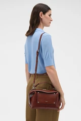 Profile view of model wearing the Oroton Mica Burnished Leather Bowler in Dark Chestnut and Smooth, vegetable-tanned leather for Women .