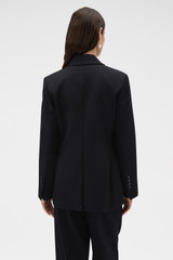Profile view of model wearing the Oroton Shaped Double Breasted Blazer in Black and 100% wool fabric for Women .