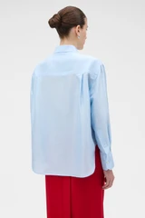 Profile view of model wearing the Oroton Silk Long Sleeve Shirt in Cloud Blue and 100% SILK DUPION for Women .