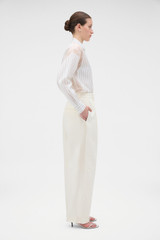 Profile view of model wearing the Oroton Barrel Leg Tuxedo Pant in Soft Cream and 100% linen fabric for Women .