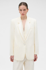 Profile view of model wearing the Oroton Oversized Tuxedo Jacket in Soft Cream and 100% linen fabric for Women .