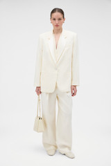 Profile view of model wearing the Oroton Oversized Tuxedo Jacket in Soft Cream and 100% linen fabric for Women .
