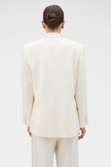 Profile view of model wearing the Oroton Oversized Tuxedo Jacket in Soft Cream and 100% linen fabric for Women .