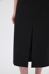 Profile view of model wearing the Oroton Split Front Skirt in Black and 100% cotton fabric for Women .