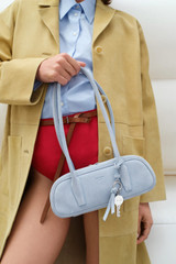 Profile view of model wearing the Oroton Louisa Suede Mini Baguette in Blue Bird and Premium suede leather for Women .