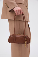 Profile view of model wearing the Oroton Louisa Smooth Mini Baguette in Chestnut and Premium smooth leather for Women .