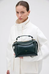 Profile view of model wearing the Oroton Mica Crackle Bowler in Shade Green and Premium crackle leather for Women .