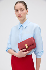 Profile view of model wearing the Oroton Etta Smooth Mini Clutch in Garnet and Smooth cow leather for Women .