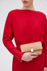 Profile view of model wearing the Oroton Etta Smooth Mini Clutch in Praline and Smooth cow leather for Women .
