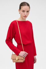 Profile view of model wearing the Oroton Etta Smooth Mini Clutch in Praline and Smooth cow leather for Women .