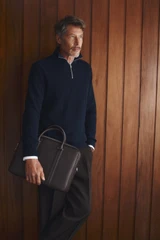 Profile view of model wearing the Oroton Nicholas Smooth Double Zip Briefcase in Dark Chocolate and Soft nappa cow leather for Men .