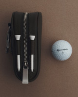 Profile view of model wearing the Oroton Luca Pebble Golf Keyring Pouch in Black and Premium pebble leather for Men .