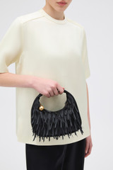 Profile view of model wearing the Oroton Clara Satin Mini Bag in Black and Satin fabric material for Women .